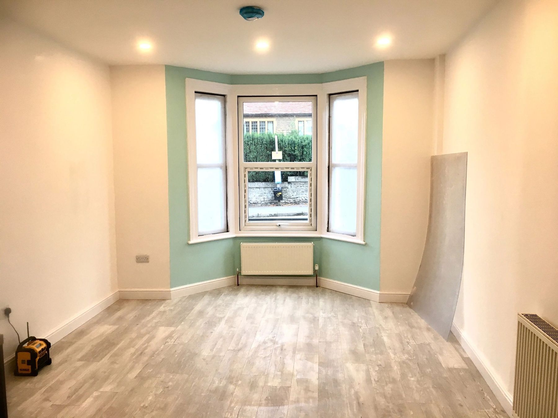 The same room finished, with a mint bay window and new flooring